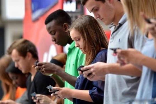 Vários jovens olhando para o celular acessando a internet